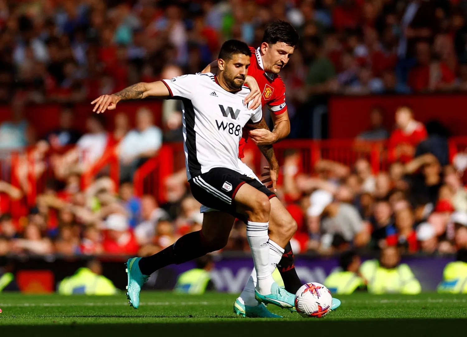 ميتروفيتش مهاجم فولهام في صراع مع مغواير لاعب مانشستر يونايتد (رويترز)