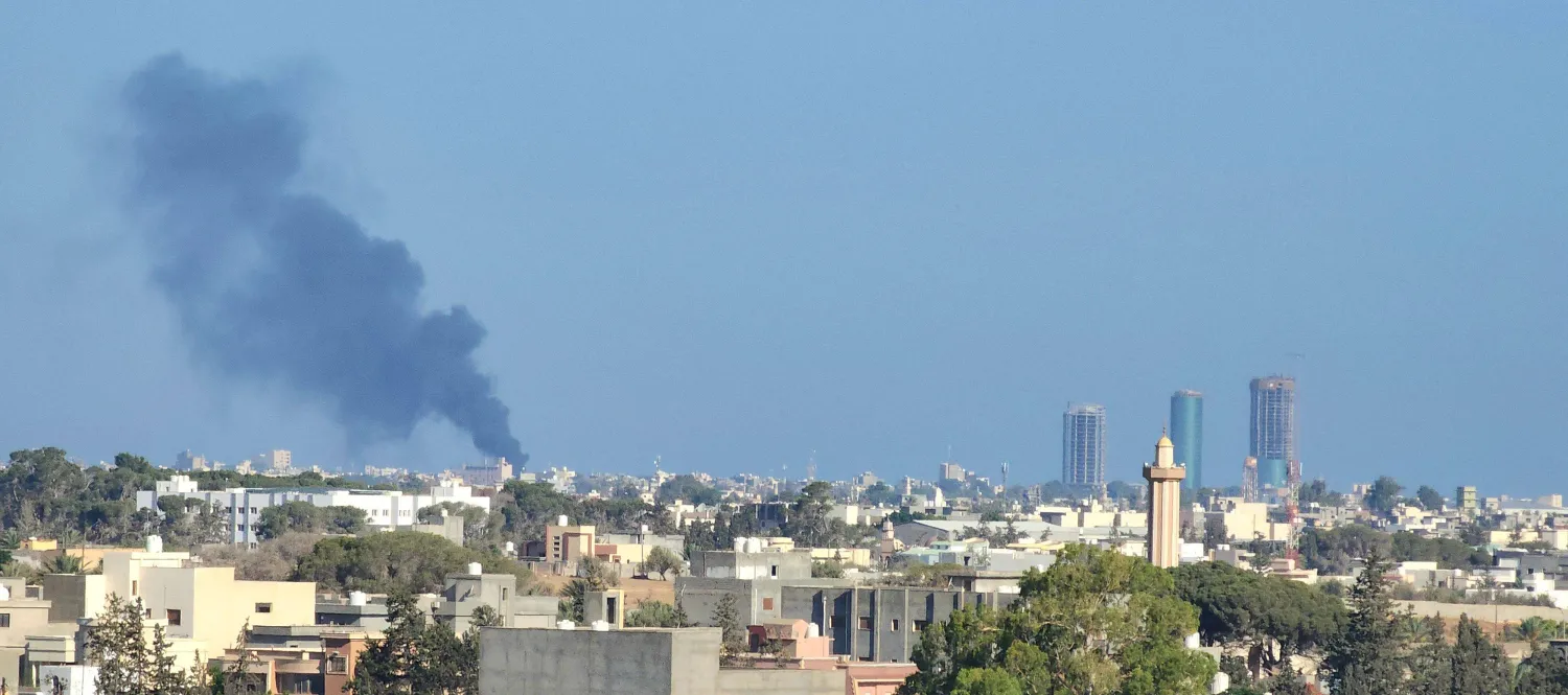 دخان يتصاعد من إحدى البنايات وسط طرابلس بسبب الاشتباكات (أ.ف.ب)