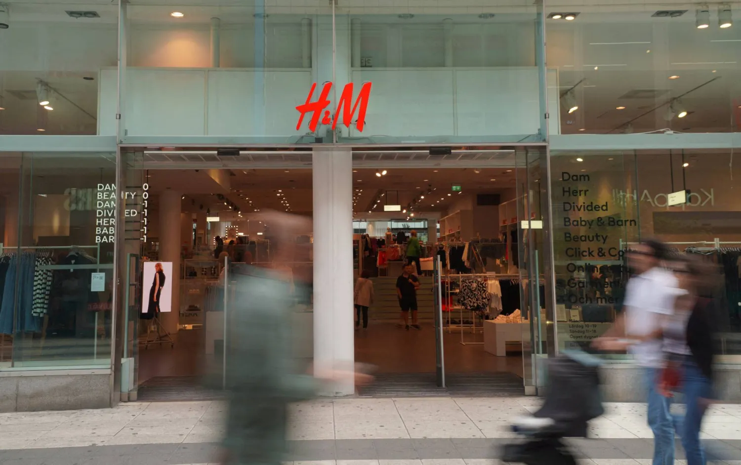 FILE PHOTO: Pedestrians and shoppers walk past a branch of fashion retailer H&M in central Stockholm, Sweden, July 17, 2023. REUTERS/Tom Little/File Photo