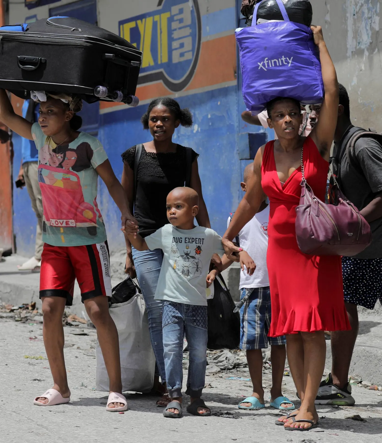 هايتيون يحملون أمتعتهم ويفرون من حيّ كارفور-فوي في العاصمة الهايتية بور أو برنس (رويترز)