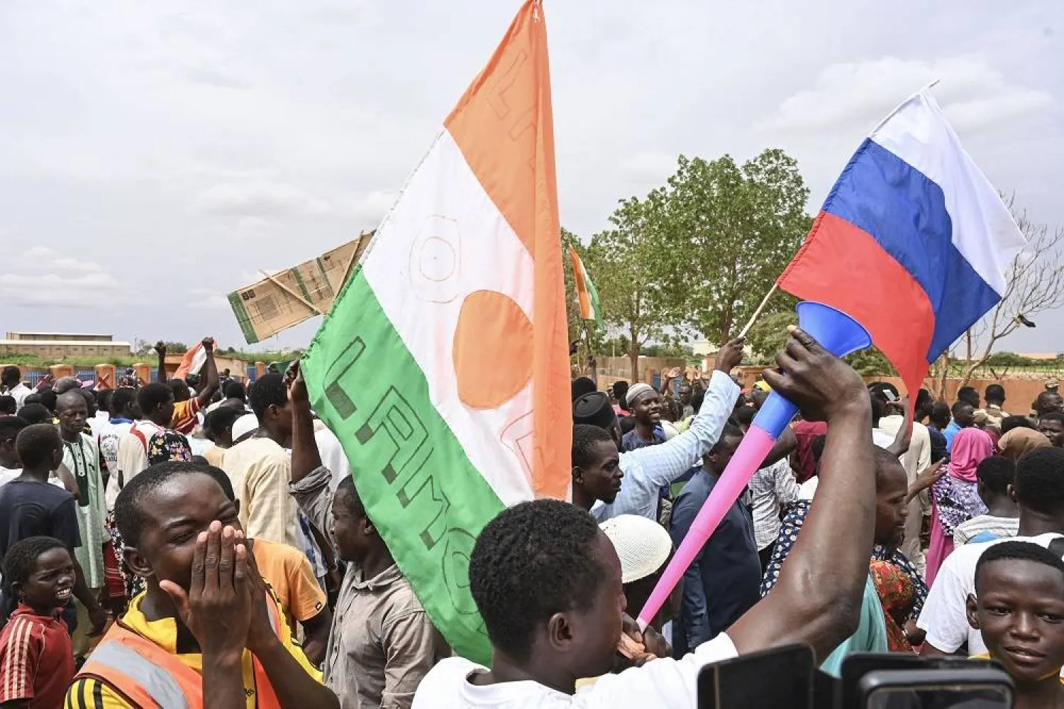 Supporters of Niger's National Council for the Safeguard of the Homeland (CNSP) hold a Niger flag (L) and a Russian flag (R) as they gather for a demonstration in Niamey on August 11, 2023 near a French airbase in Niger. (AFP)