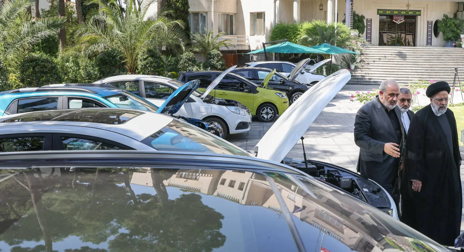 رئيسي يطلع على سيارات جديدة ويبدو خلفه وزير الصناعة عباس علي آبادي (الرئاسة الإيرانية)