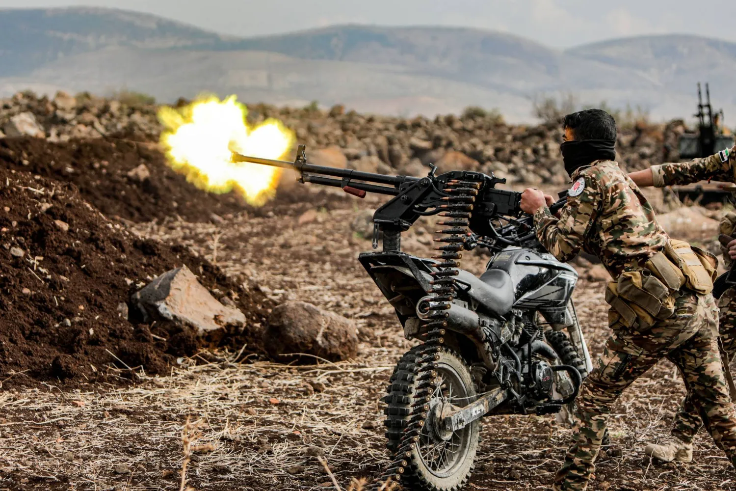 مقاتل سوري يطلق النار من مدفع رشاش مثبت على دراجة نارية خلال تدريبات عسكرية نفذتها «فرقة السلطان سليمان شاه» المدعومة من تركيا في منطقة عفرين 22 نوفمبر 2022 (أ.ف.ب)