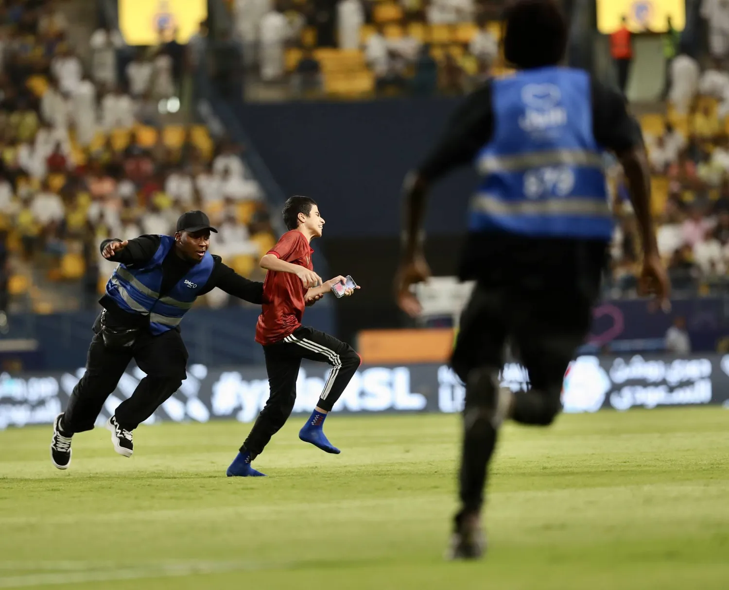 رجال أمن يطاردون أحد المشجعين الذين اقتحموا أرضية الملعب خلال مباراة النصر والتعاون الأخيرة (تصوير: عبدالعزيز النومان)