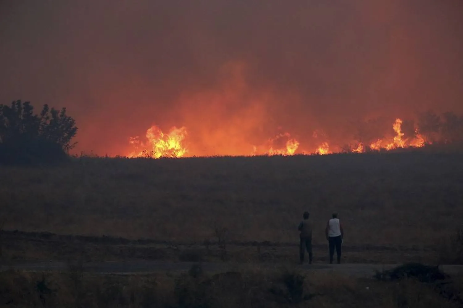 People watch the flames during a wildfire near the northeastern town of Alexandroupolis, Greece, Sunday, Aug. 20, 2023. (AP)