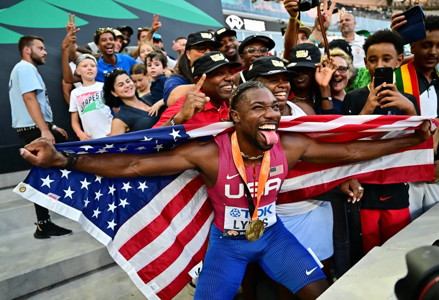 الأميركي نواه لايلز محتفلاً مع الجماهير بذهبية الـ100م في مونديال العالم لألعاب القوى (رويترز) 