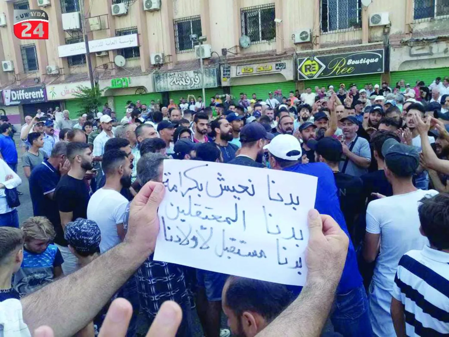 لافتات رفعها المحتجّون في ساحة السير - الكرام وسط مدينة السويداء الأحد (السويداء 24)
