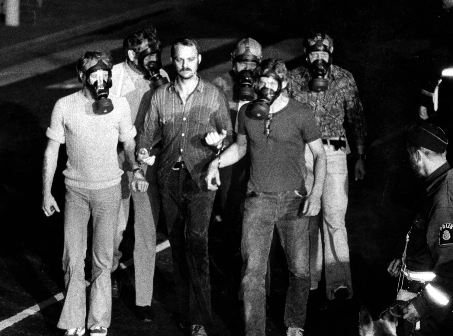 عناصر من الشرطة تقبض على يان إريك أولسن الذي ظهر بقناع على وجهه (أ.ف.ب)