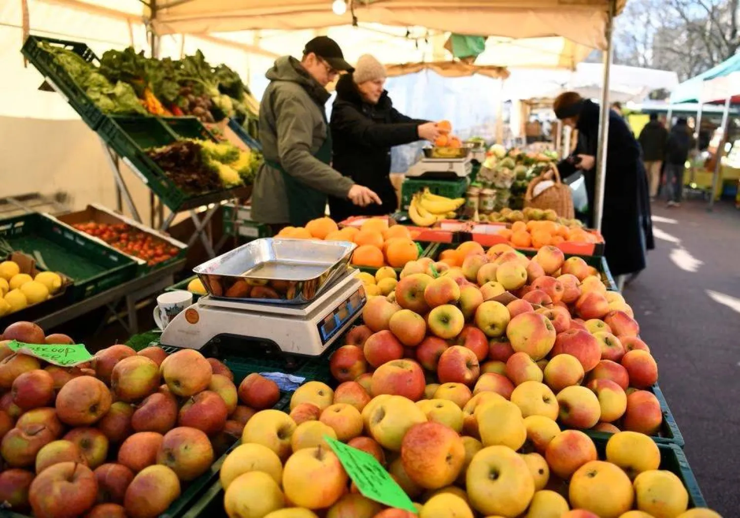 متسوقون يشترون فاكهة في إحدى الأسواق الشعبية في العاصمة الألمانية برلين (رويترز)
