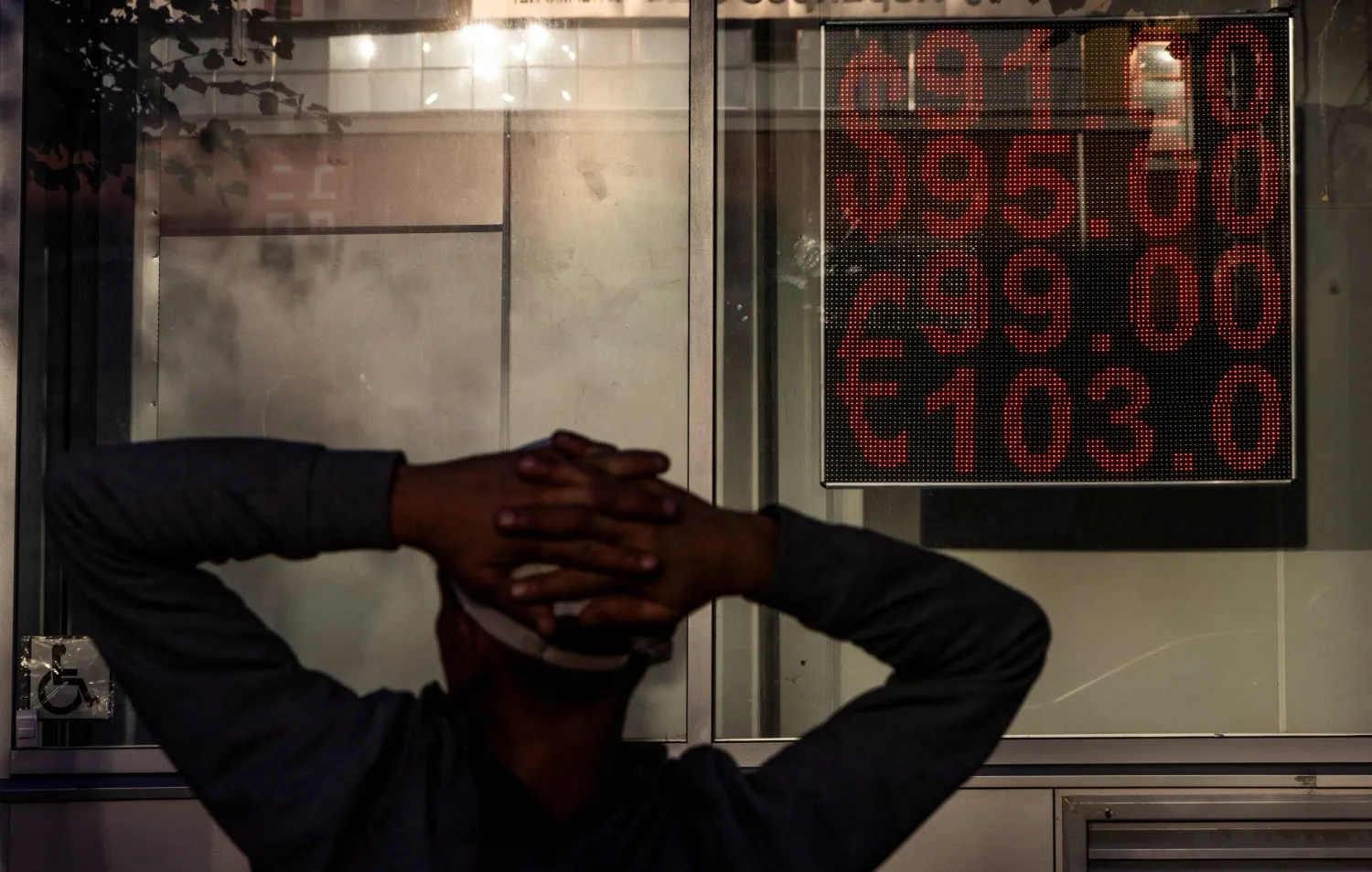 رجل يتابع هبوط العملة الروسية بالأسواق الأسبوع الماضي على شاشة في العاصمة الروسية موسكو (رويترز)