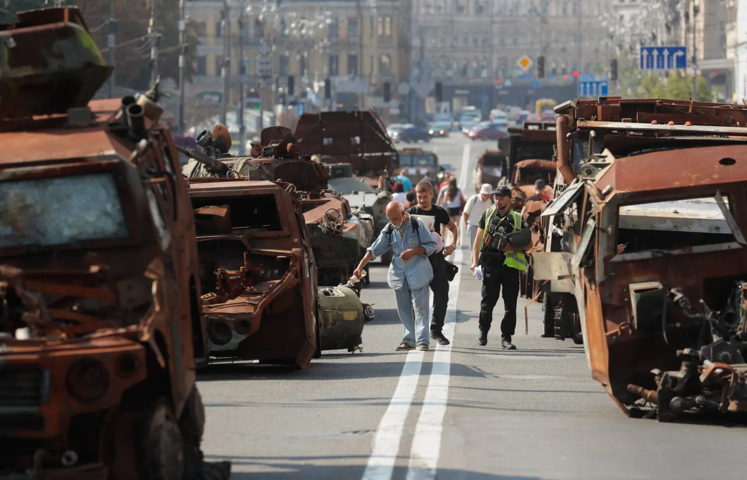 أوكرانيون يسيرون أمام مركبات عسكرية روسية متضررة استولى عليها الجيش الأوكراني في كييف الاثنين قبل احتفالات يوم الاستقلال المقررة في 24 أغسطس (إ.ب.أ)