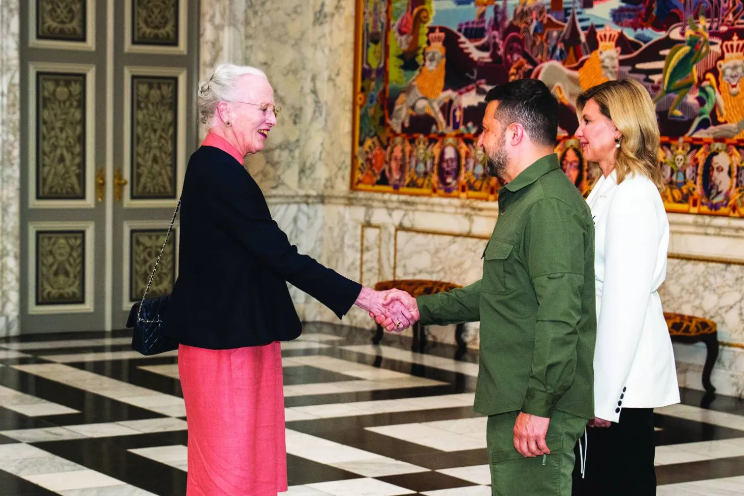 
ملكة الدنمارك مارغريت الثانية لدى ترحيبها بالرئيس الأوكراني فولوديمير زيلينسكي وزوجته أولينا زيلينسكا في البرلمان الدنماركي في كوبنهاغن أمس (إ.ب.أ)