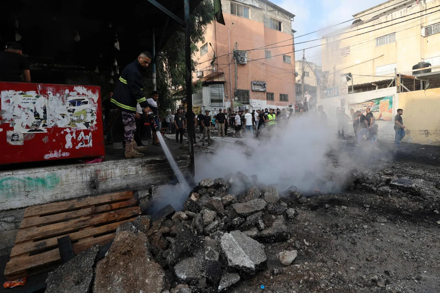 رجل إطفاء فلسطيني يخمد النيران عقب توغل القوات الإسرائيلية للبحث عن مطلوبين في مخيم نور شمس للاجئين شرق طولكرم (أ.ف.ب)