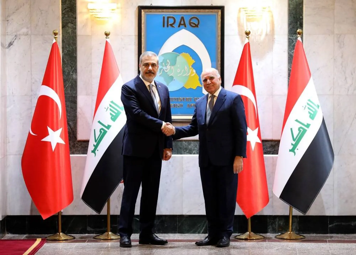Iraqi Foreign Minister Fuad Hussein (R) welcomes Turkish Foreign Minister Hakan Fidan (L) at the Iraqi ministry of foreign affairs in Baghdad, Iraq, 22 August 2023. (EPA) 