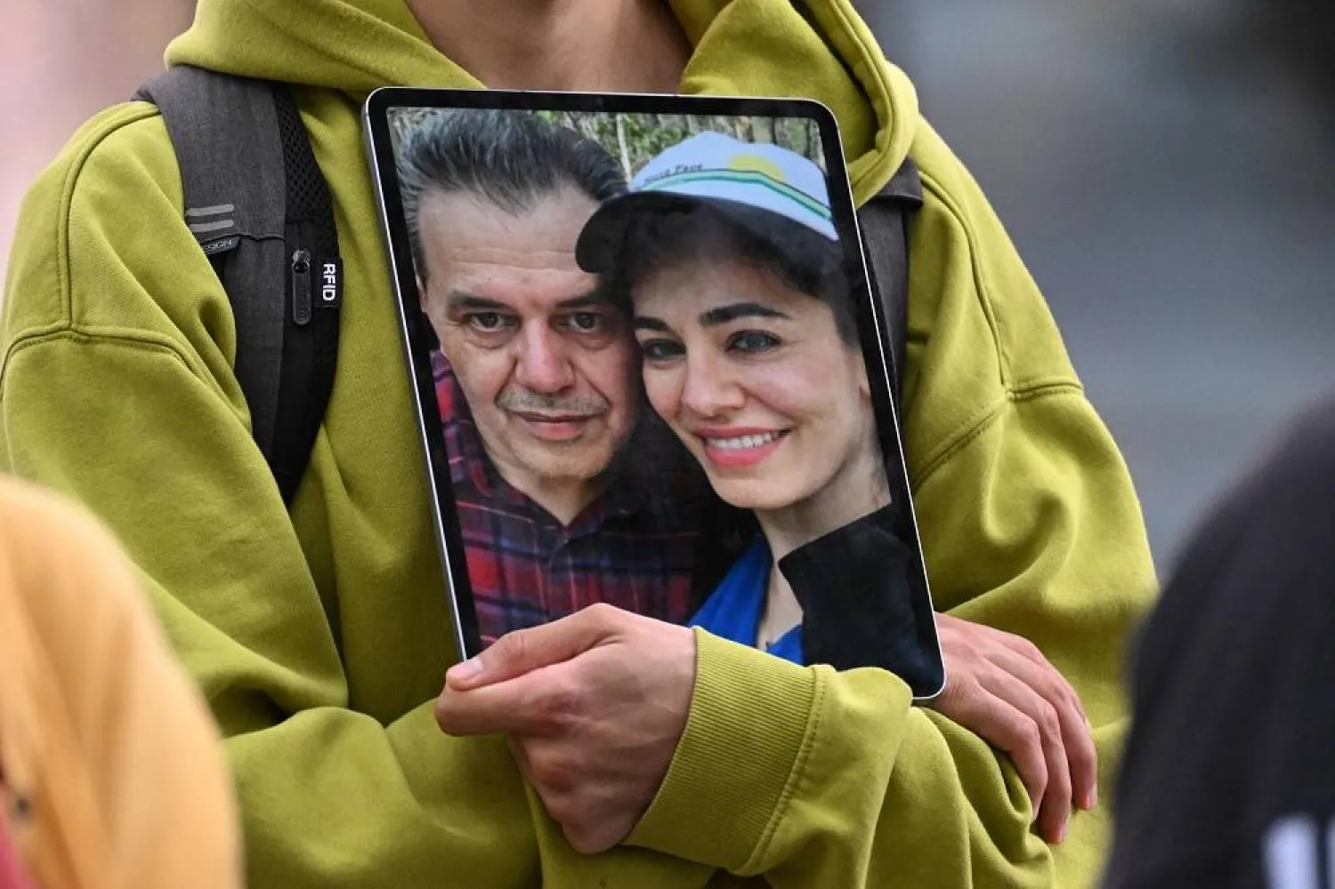 A demonstrator holds a picture of Iranian-German Jamshid Sharmahd (L), who has been sentenced to death in Iran, with his daughter Gazelle Sharmahd during a demonstration for his release in front of the German Foreign Ministry in Berlin on July 31, 2023. (AFP) 