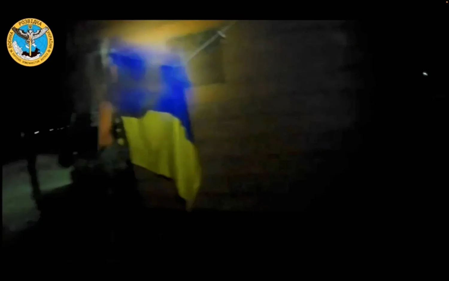 جندي أوكراني يعلق علم بلاده خلال عملية قامت بها القوات الأوكرانية في موقع تم تحديده بالقرب من مستوطنتي أولينيفكا وماياك، في شبه جزيرة القرم (رويترز)