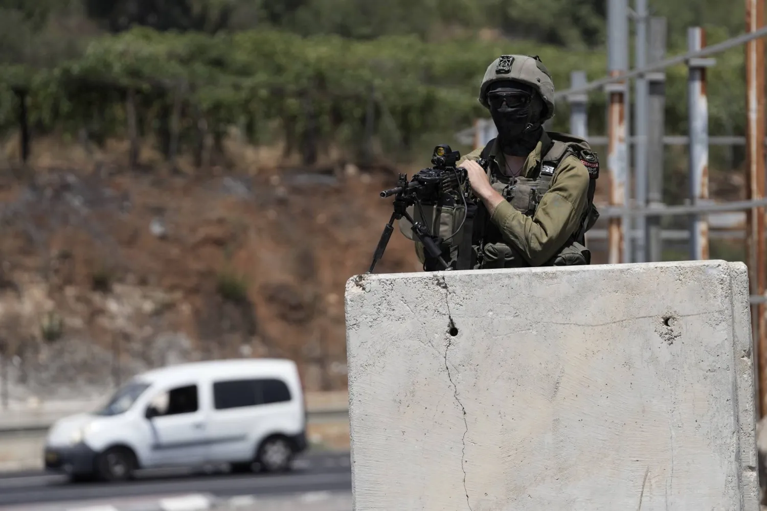 An Israeli soldier secures the entrance to the West Bank city of Hebron, a day after a deadly shooting attack that killed an Israeli woman and seriously wounded a man near the city, Tuesday, Aug. 22, 2023.(AP Photo/Mahmoud Illean)