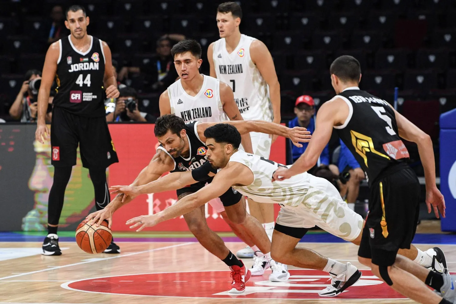 صراع قوي على الكرة خلال مباراة الأردن ونيوزيلندا (أ.ف.ب)