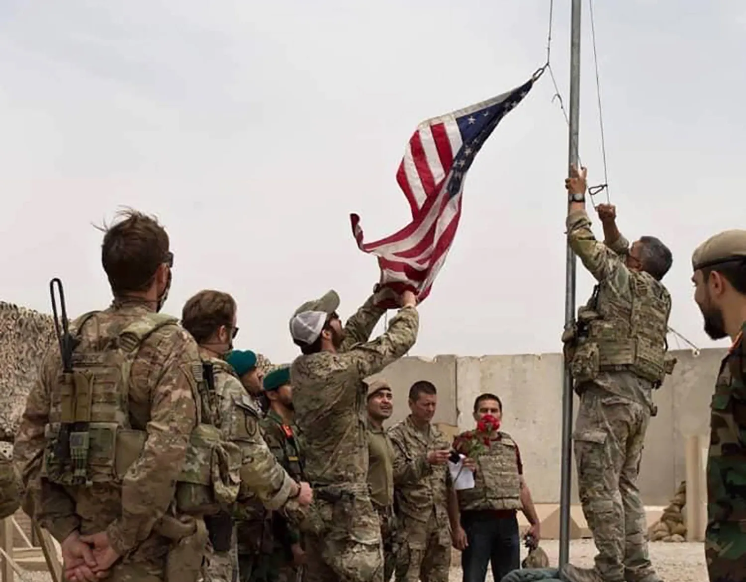 يجري إنزال العلم الأميركي بينما يحضر الجنود الأميركيون والأفغان حفل تسليم من الجيش الأميركي إلى الجيش الوطني الأفغاني في معسكر أنتونيك في مقاطعة هلمند بجنوب أفغانستان (أ.ب)