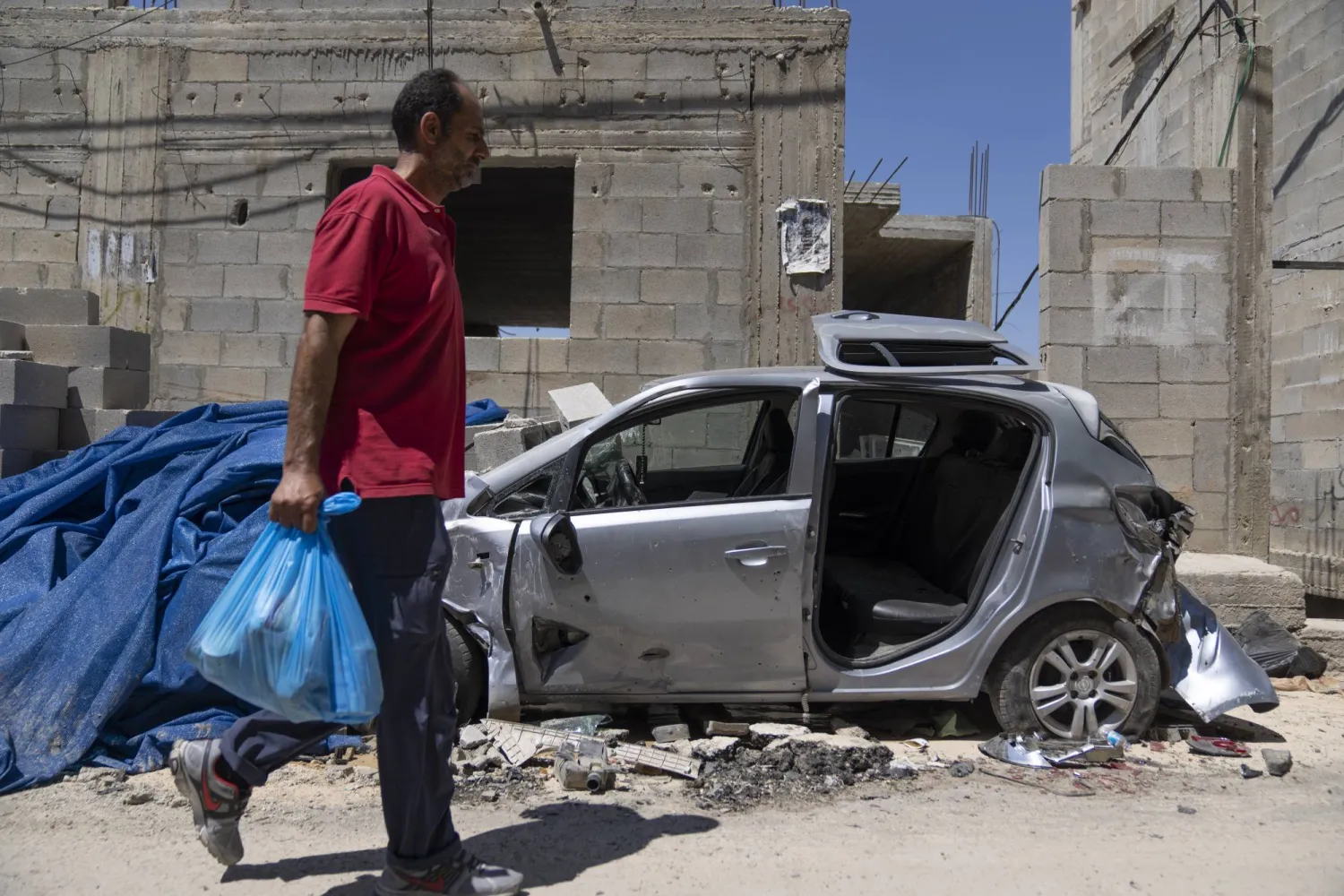 موظف في منظمة «البسمة الخيرية» يسلم طرود مساعدات غذائية للعائلات المتضررة من العملية العسكرية الإسرائيلية لمخيم جنين (أ.ب)