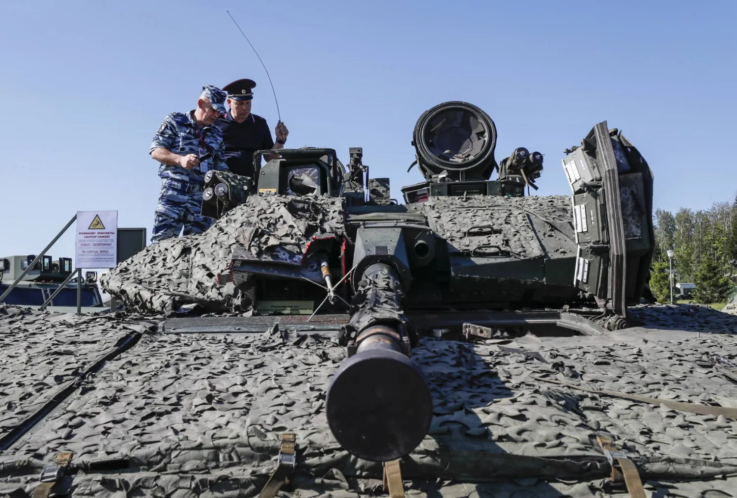 جنود روس ينظرون إلى مركبة قتالية سويدية خلال معرض الأسلحة التي تم الاستيلاء عليها أثناء العملية العسكرية الروسية الخاصة في أوكرانيا (إ.ب.أ)