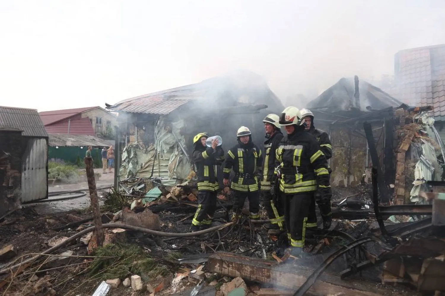 Firefighters take a break while trying to extinguish a fire in a building that was damaged following a missile attack in a village outside Kyiv on August 30, 2023, amid the Russian invasion of Ukraine. (AFP)