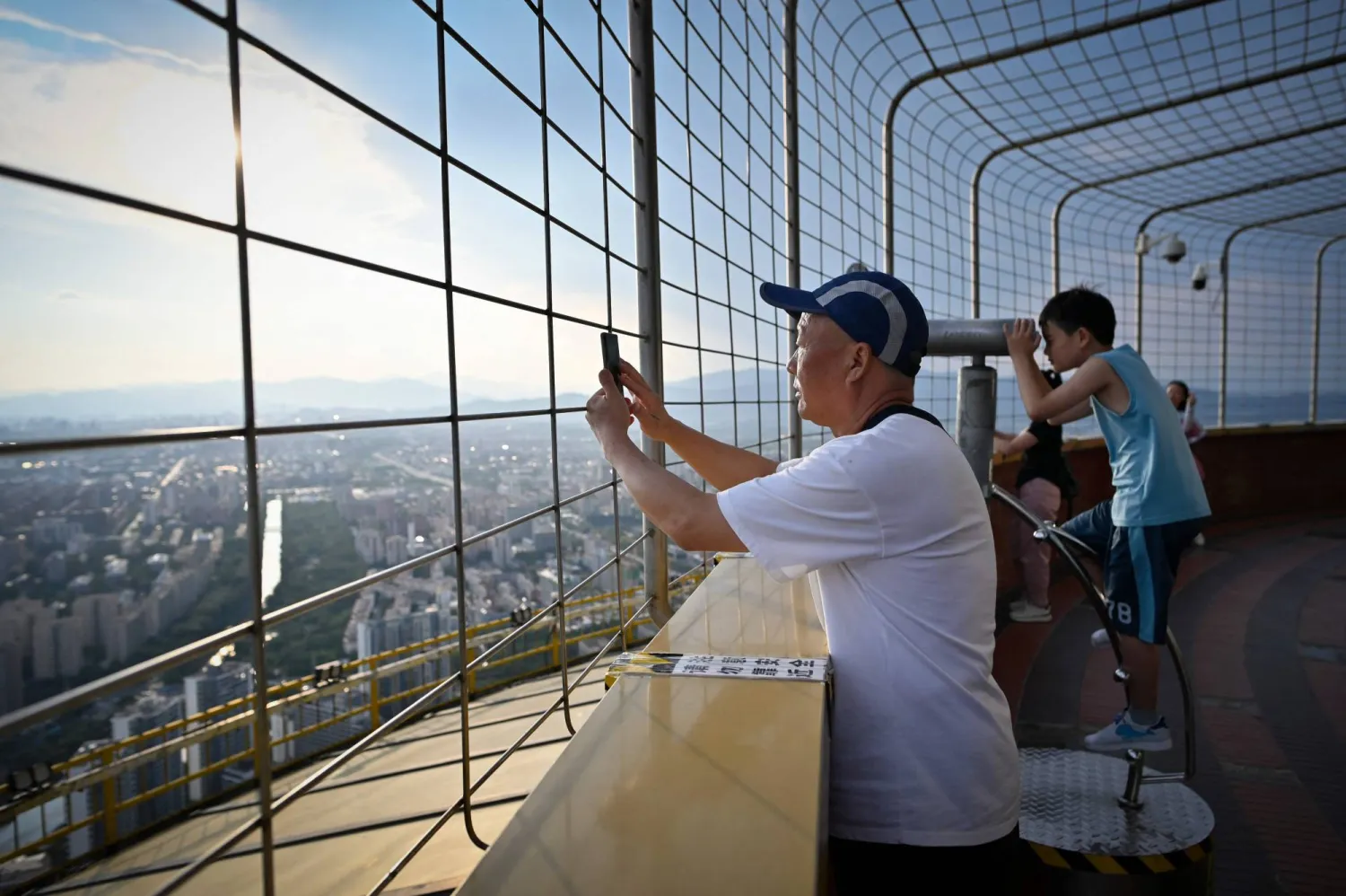 صينيون يأخذون لقطات تذكارية ويشاهدون الأفق خلال زيارة لبرج الإذاعة والتليفزيون في وسط العاصمة بكين (أ.ف.ب)