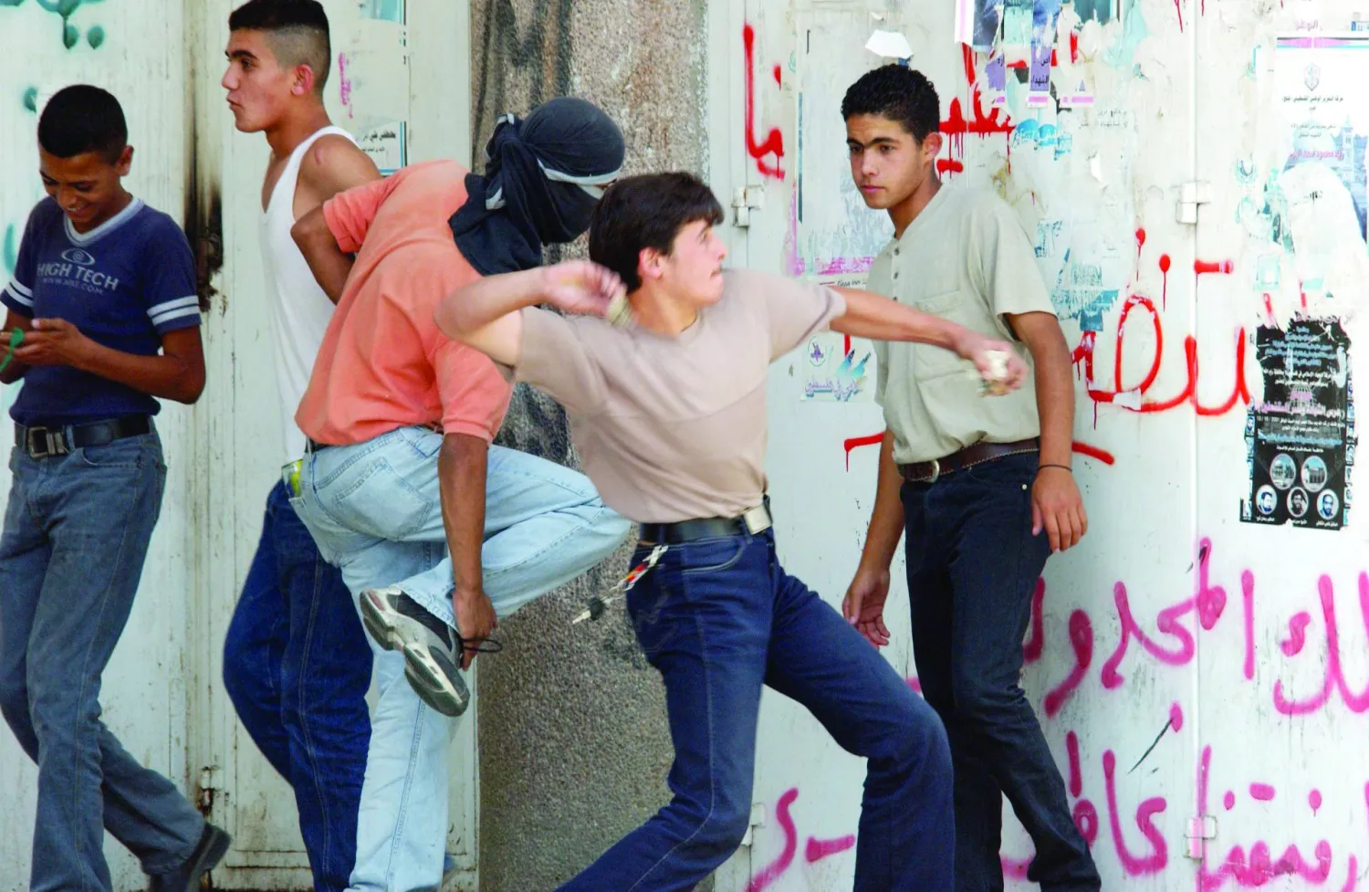 شاب فلسطيني برام الله يرمي حجراً على دوريات الجنود الإسرائيليين في سبتمبر 2002 في ذكرى الانتفاضة الثانية (غيتي)