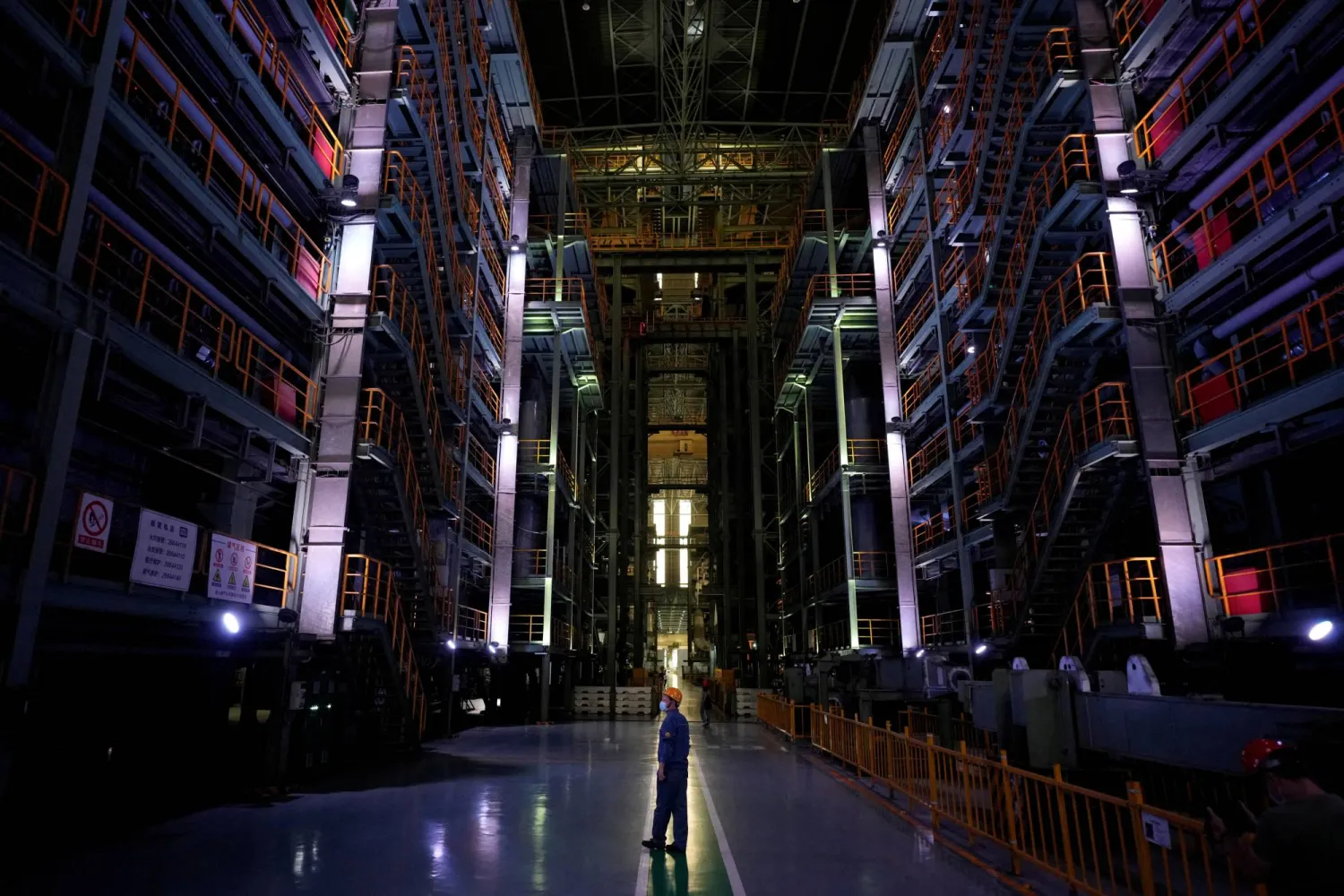 عامل يقف وسط أحد مصانع الحديد والصلب في مدينة شنغهاي الصينية (رويترز)