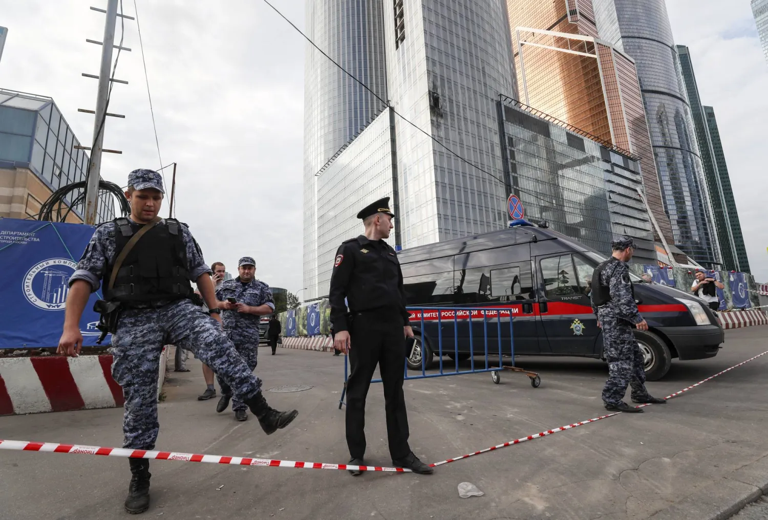 عناصر من الشرطة يتجمعون بجوار مبنى متضرر في المركز التجاري لمدينة موسكو بعد سقوط مسيّرة (إ.ب.أ)