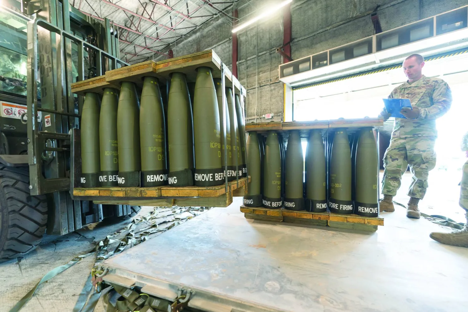 FILE - US Air Force Staff Sgt. Cody Brown, right, with the 436th Aerial Port Squadron, checks pallets of 155 mm shells ultimately bound for Ukraine, April 29, 2022, at Dover Air Force Base, Del. US officials say the Pentagon will announce it is sending up to $500 million in military aid to Ukraine, including more than 50 heavily armored vehicles and an infusion of missiles for air defense systems.(AP Photo/Alex Brandon, File)