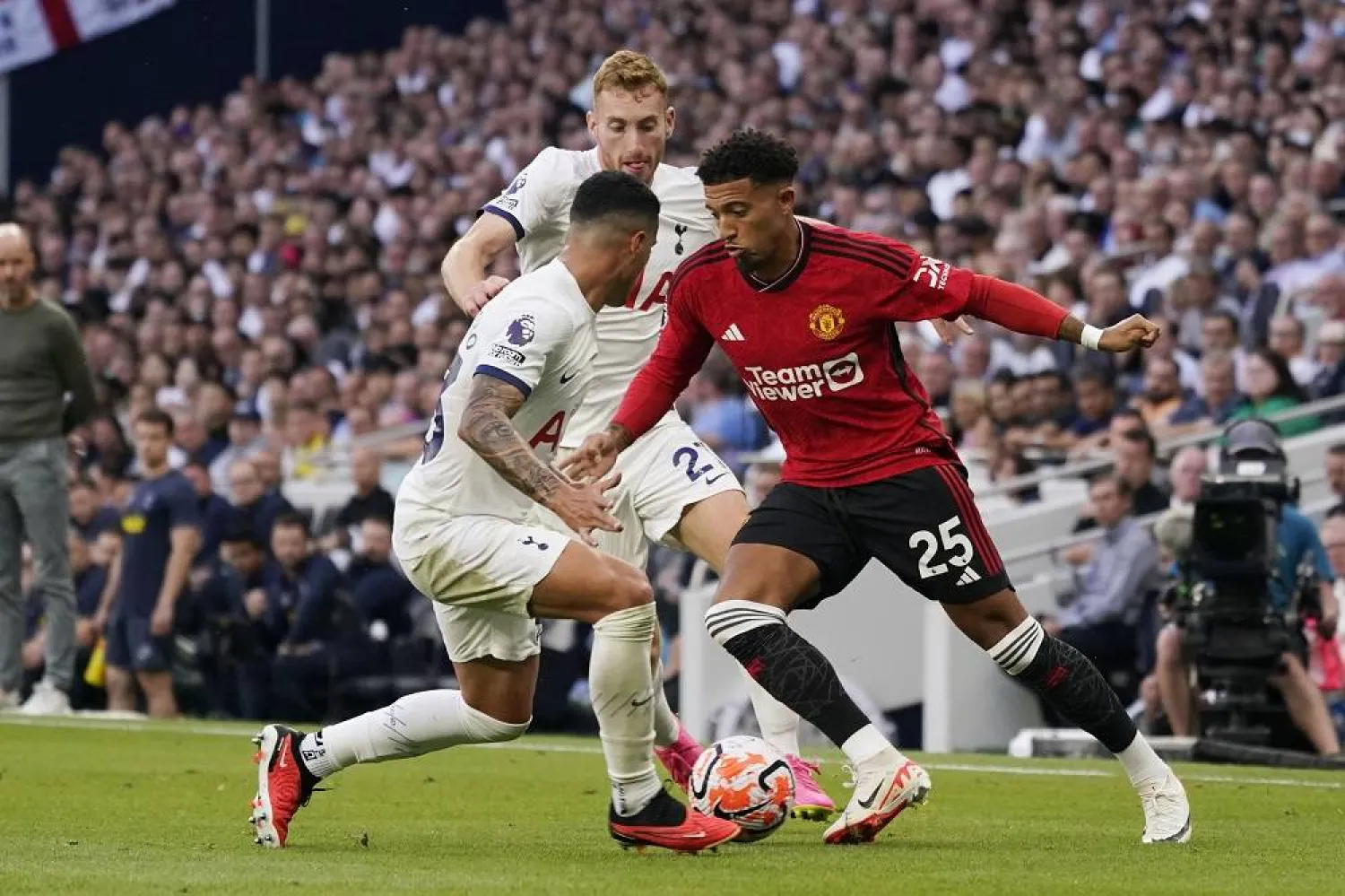 Manchester United's Jadon Sancho, right, and Tottenham's Pedro Porro challenge for the ball during the Premier League soccer match between Tottenham Hotspur and Manchester United at the Tottenham Hotspur Stadium in London, England, Saturday, Aug. 19, 2023. (AP)