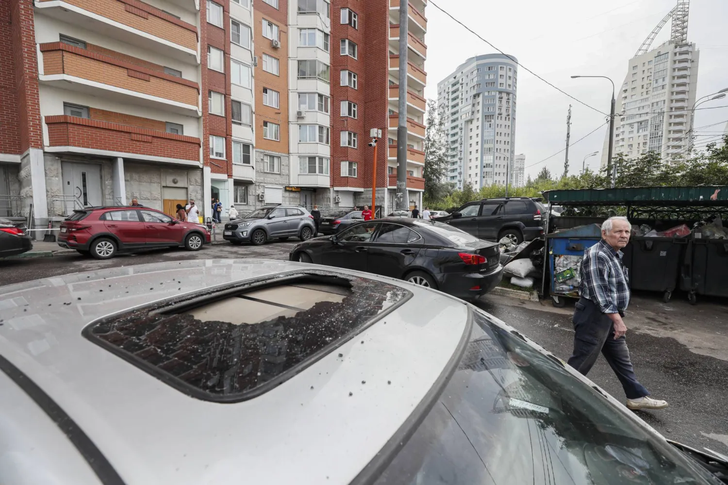 رجل يسير بجوار سيارة متضررة بعد إسقاط مسيرتين، في كراسنوغورسك، بمنطقة موسكو، ، 22 أغسطس 2023 (إ.ب.أ)