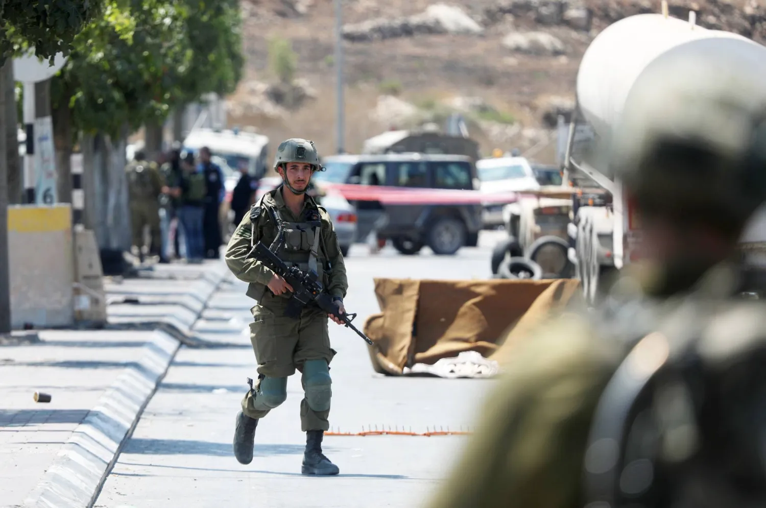 30 August 2023, Palestinian Territories, Hebron: Israeli forces work at the crime scene after a ramming attack in the West Bank city of Hebron. Photo: Mamoun Wazwaz/APA Images via ZUMA Press Wire/dpa