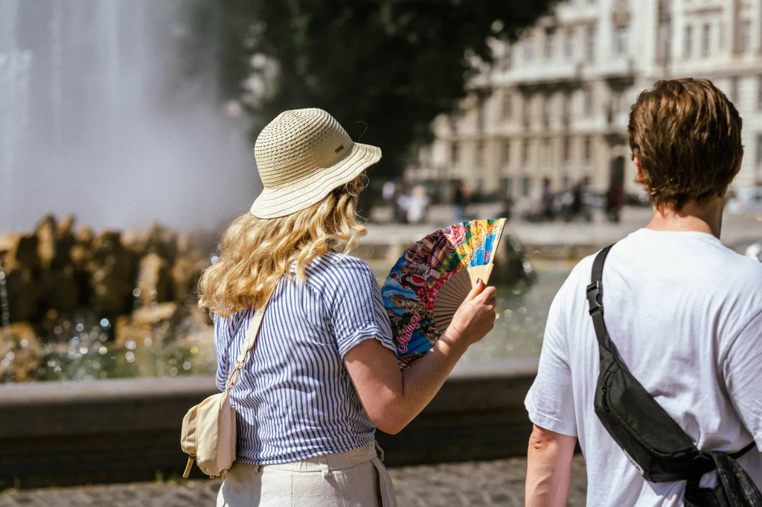 A woman uses a fan to cool off during a heatwave in Vienna, Austria, August 25, 2023. REUTERS/Julia Geiter
