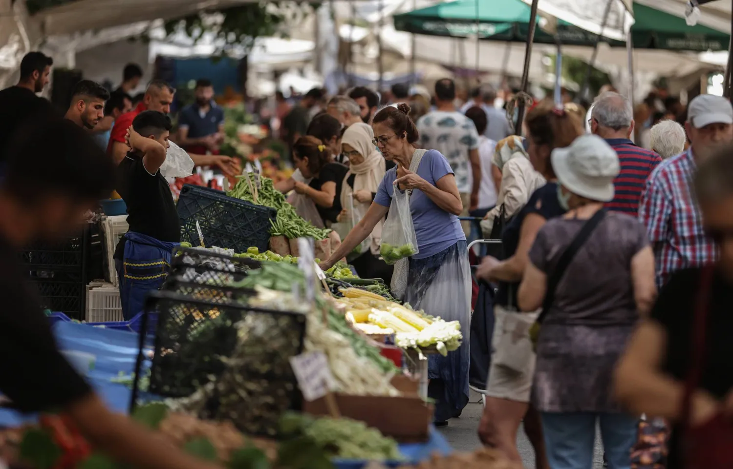 أتراك يتسوقون في إحدى الأسواق الشعبية بمدينة إسطنبول التركية (إ.ب.أ)