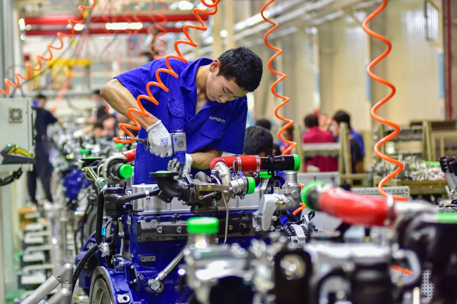 Bir işçi, Çin’in Shandong Eyaleti’ndeki Qingzhou’da bulunan bir motor üretim tesisinde motor montajı yapıyor (AFP)