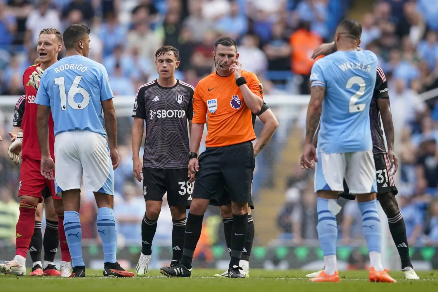 الحكم مايكل أوليفر ينصت إلى آراء «غرفة الفار» في هدف مانشستر سيتي المثير للجدل (أ.ب)