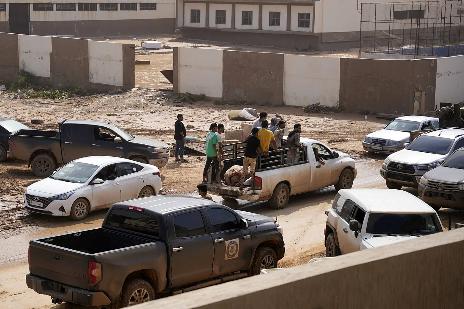 أشخاص يتفقدون الأضرار في منطقة غمرتها الفيضانات بمدينة درنة الشرقية على بعد نحو 290 كيلومتراً شرق بنغازي (أ.ف.ب)