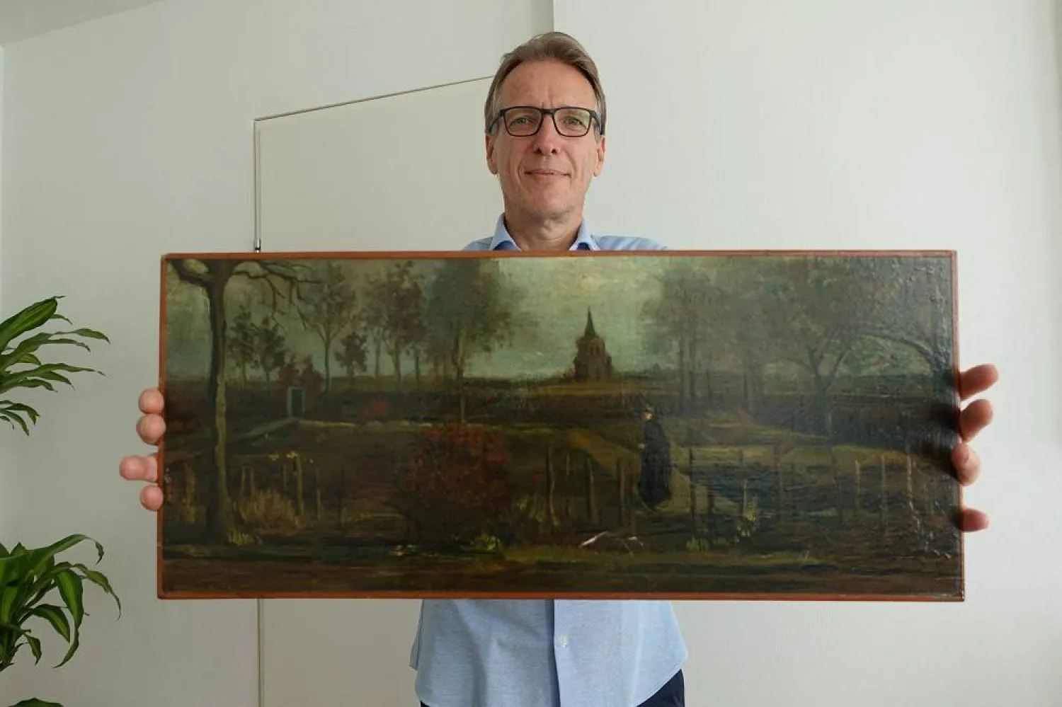 A handout picture released by Dutch art detective Arthur Brand shows a portrait of him posing with the painting title "Parsonage Garden at Nuenen in Spring", painted by Vincent van Gogh in 1884, at his home in Amsterdam on September 11, 2023. (AFP photo /Arthur Brand) 