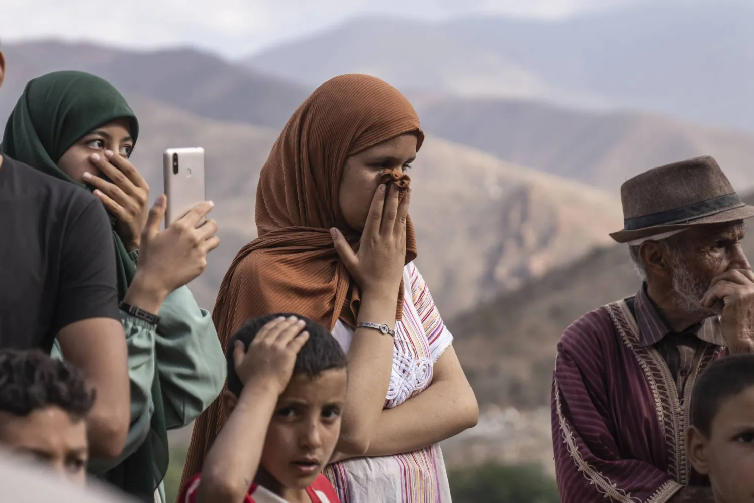 12 Eylül 2023 salı günü Fas’ın Marakeş dışındaki Imi Natala beldesinde depremde ölen bir kadının cesedinin çıkarılması sırasında insanların tepkisi. (AP)