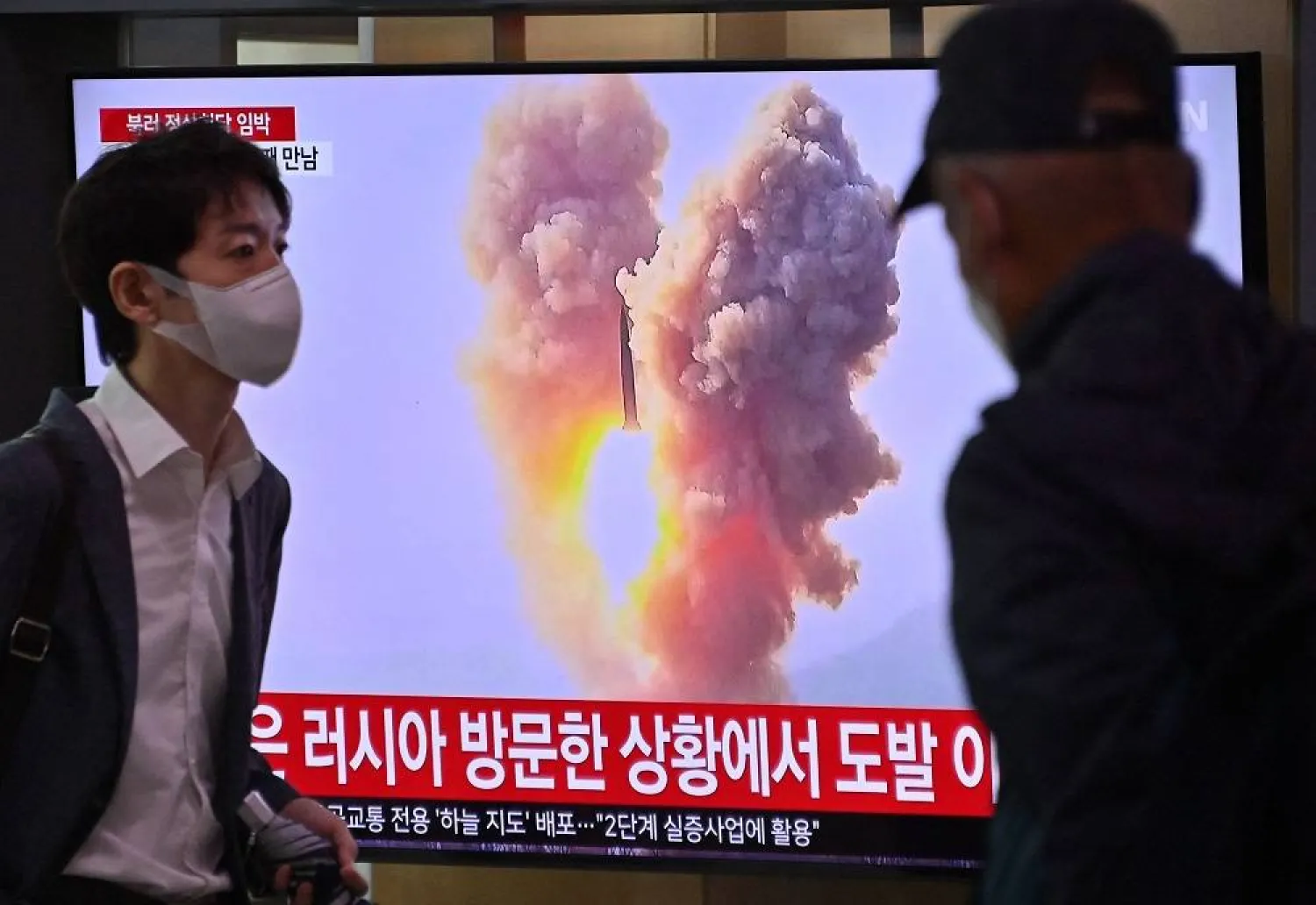 A man walks past a television screen showing a news broadcast with file footage of a North Korean missile test, at a railway station in Seoul on September 13, 2023. (AFP) 