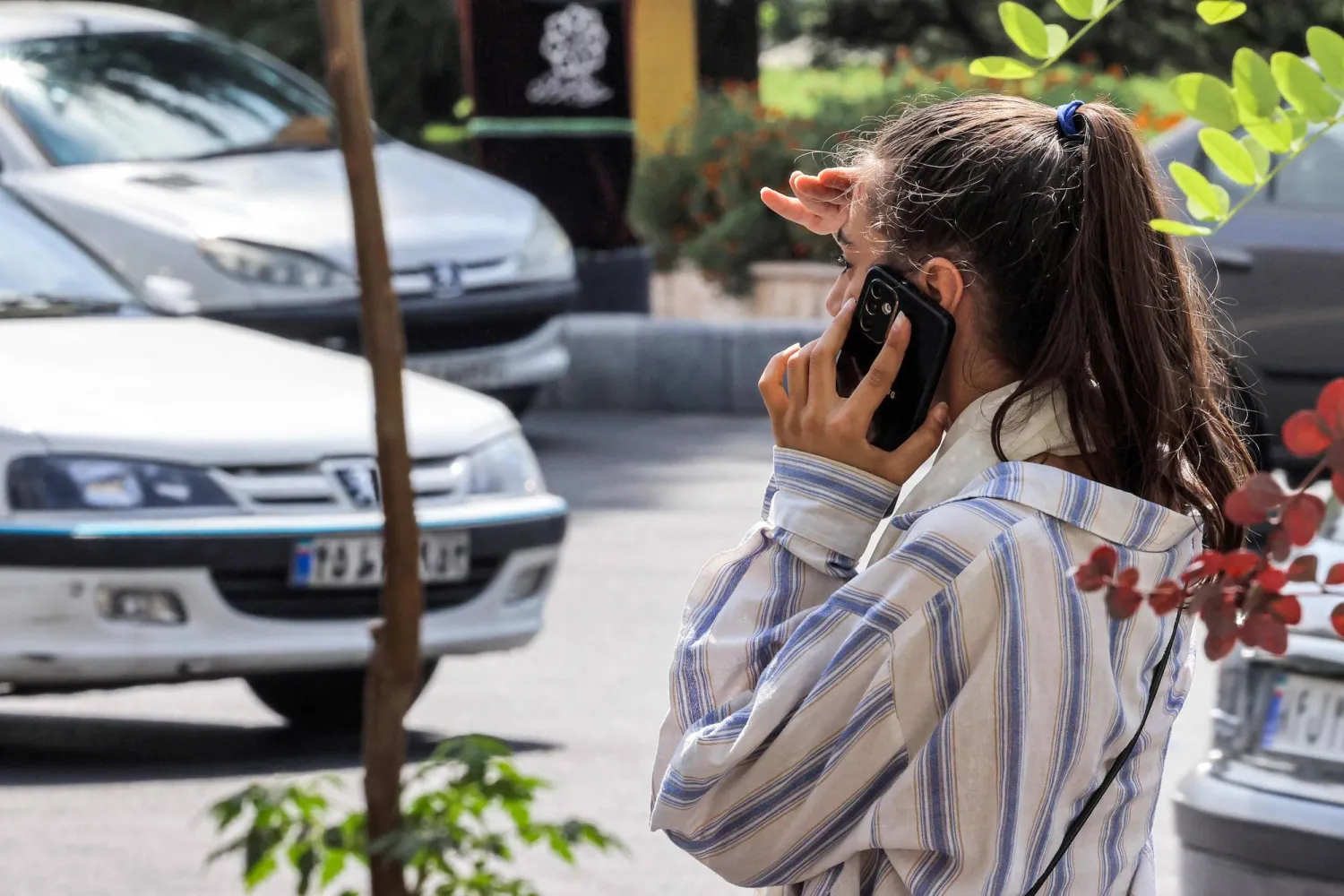 إيرانية تخلع الحجاب تتحدث بالهاتف في شارع وسط طهران 4 سبتمبر الحالي (أ.ف.ب)