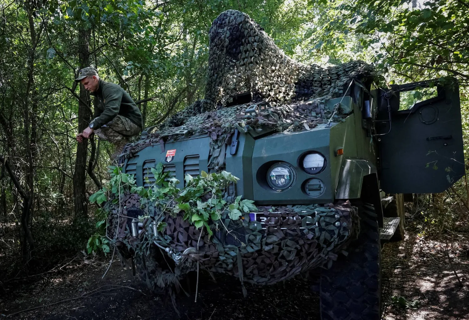 جندي أوكراني يجلس على مدفع هاوتزر ذاتي الحركة قرب دونيتسك (رويترز)