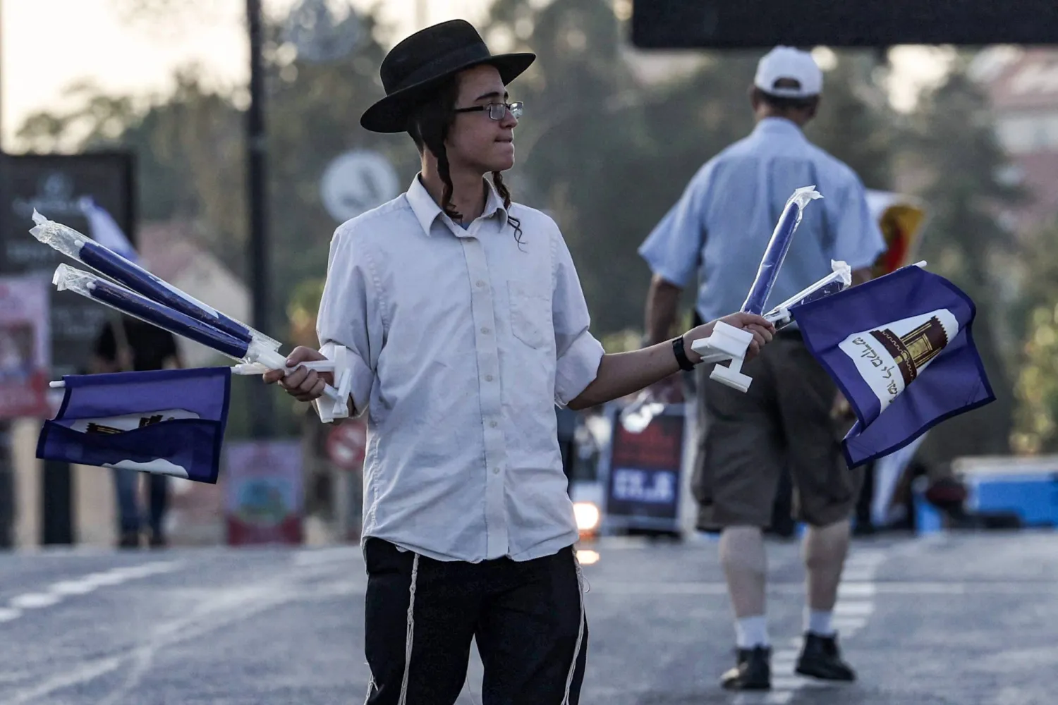 يهودي متطرف يوزع أعلاماً لحركة «المعبد الثالث» بالقدس في 7 سبتمبر الحالي (أ.ف.ب) 