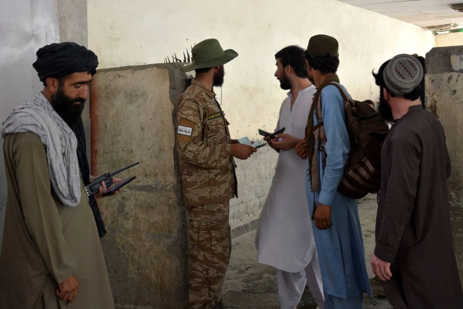 مسؤولو الأمن يتحققون من وثائق الأشخاص الذين يعبرون إلى أفغانستان من باكستان بعد أن أعلنت الحكومة الباكستانية إعادة فتح حدود طورخم بعد إغلاق دام تسعة أيام (إ.ب.أ)