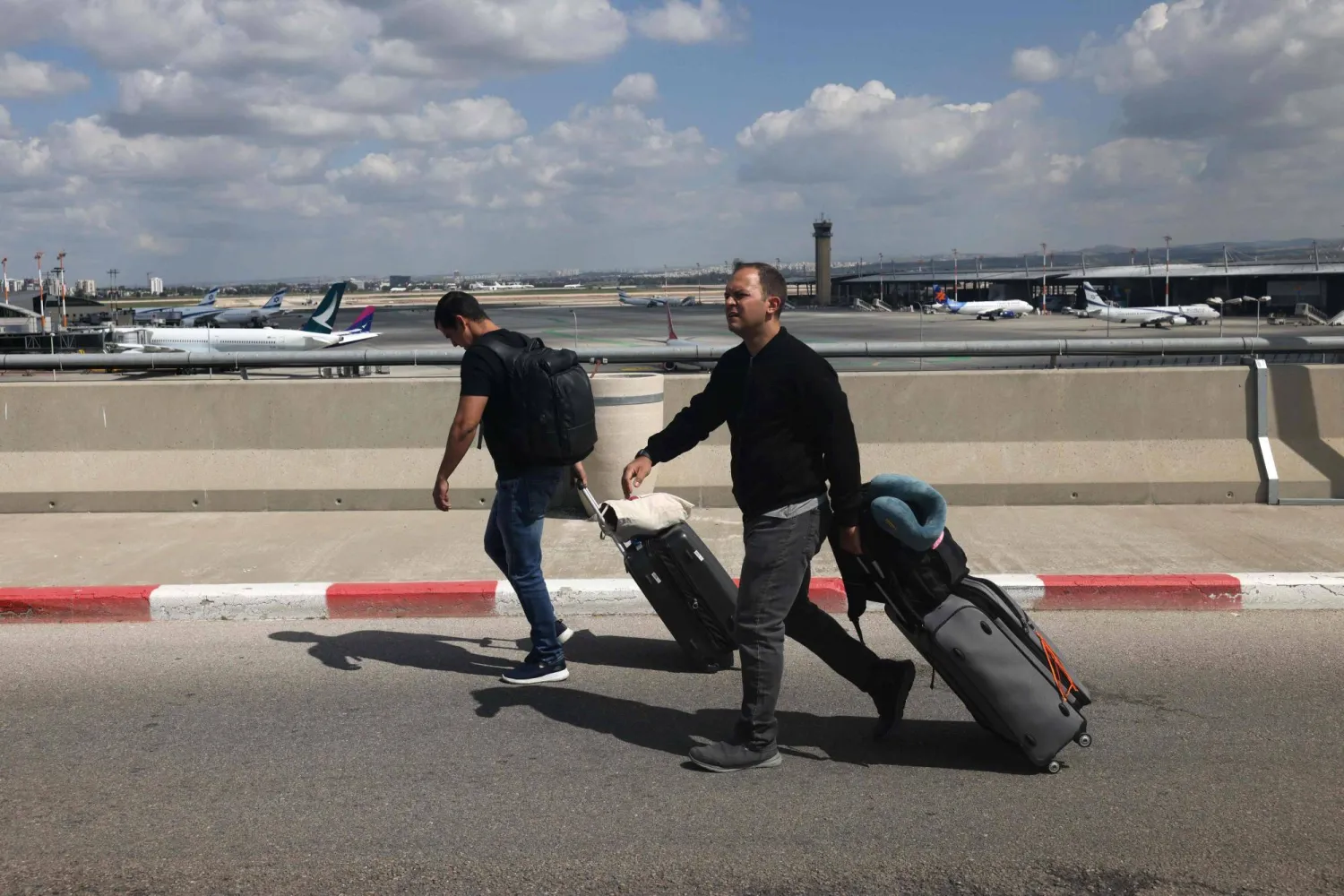 مسافران يتجهان إلى نقطة المغادرة في مطار بن غوريون (أرشيفية - أ.ف.ب)