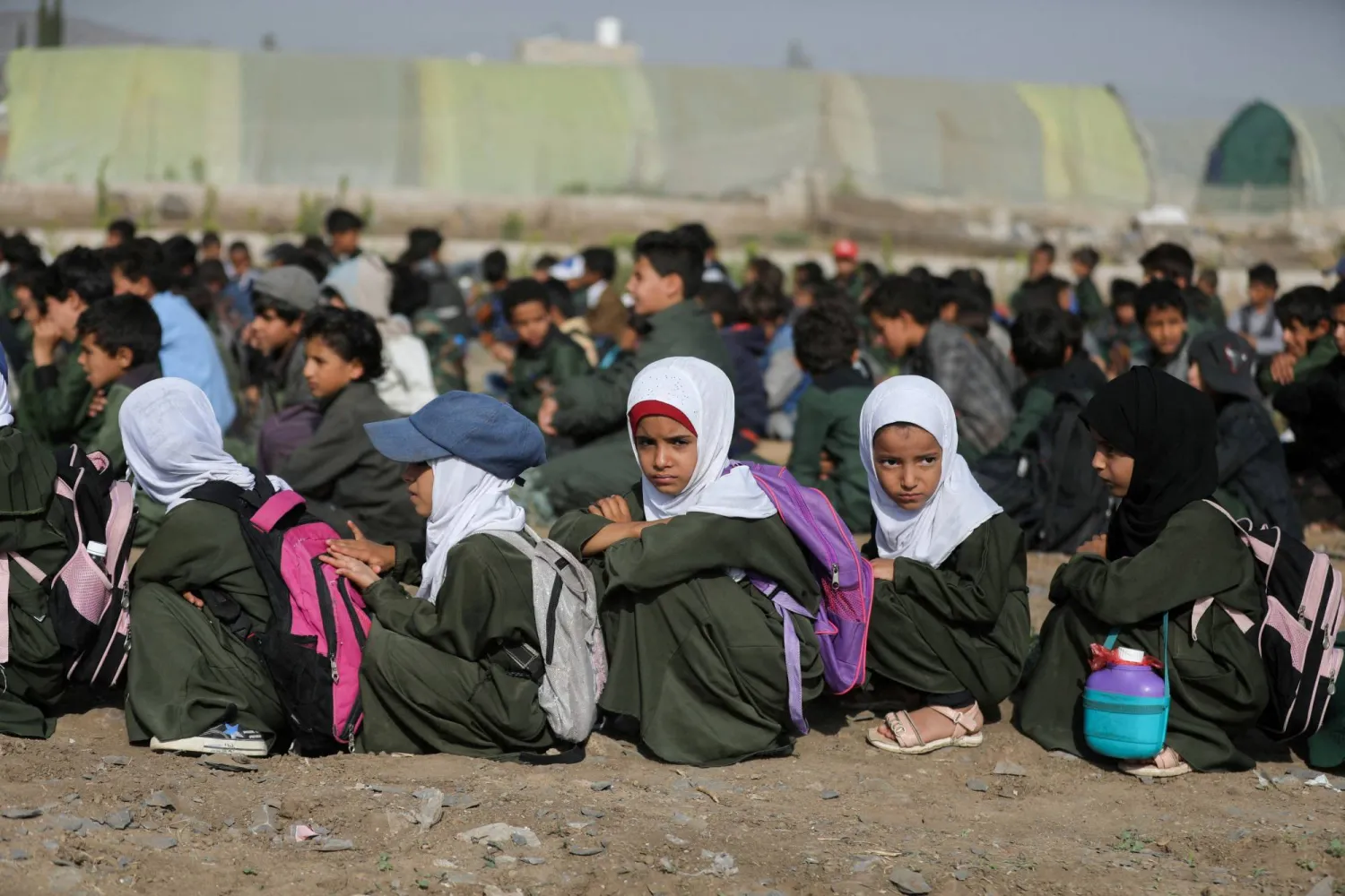 FILE PHOTO: Students use paper sheets to shelter from the sun while waiting for the opening of a new school on the outskirts of Sanaa, Yemen September 2, 2023. REUTERS/Khaled Abdullah/File Photo