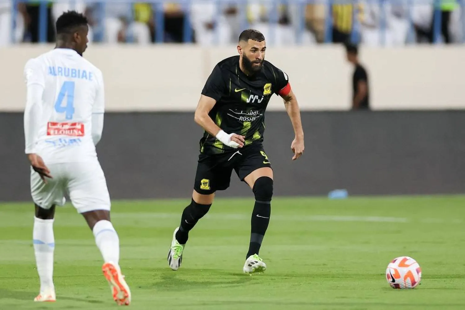 Ittihad's French forward #09 Karim Benzema vies for the ball with Akhdoud's defender #04 Saeed Alrubaei during the Saudi Pro League football match between Al-Ittihad and Al-Akhdoud at Prince Hathloul bin Abdulaziz Stadium in Najran on September 14, 2023. (AFP) 
