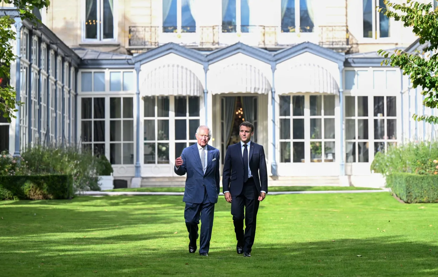 الملك تشارلز والرئيس ماكرون في باحة منزل السفير البريطاني لدى فرنسا (رويترز)